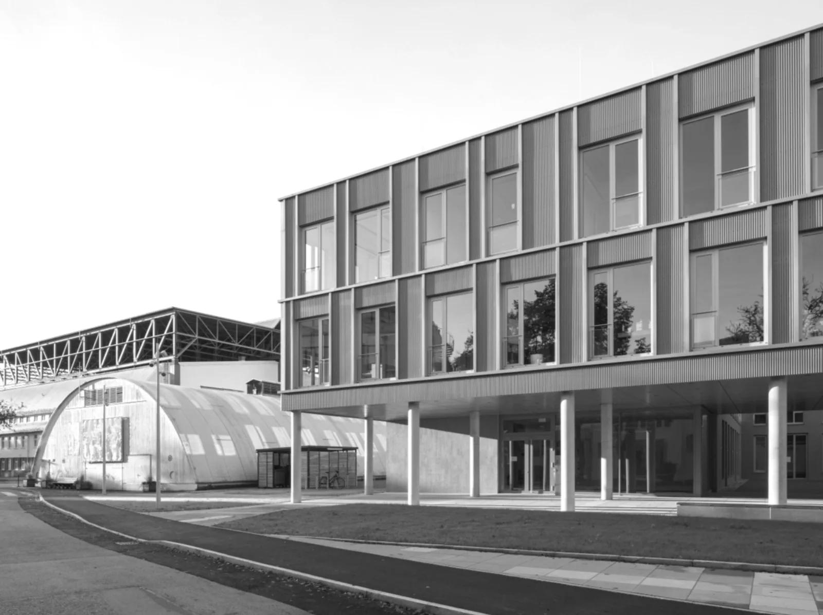 Bürogebäude mit vertikal profilierter Fassade und offener Kolonnade im Erdgeschoss